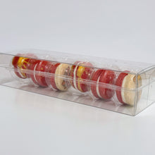 Load image into Gallery viewer, Clear plastic container with red and gold macarons on a white background
