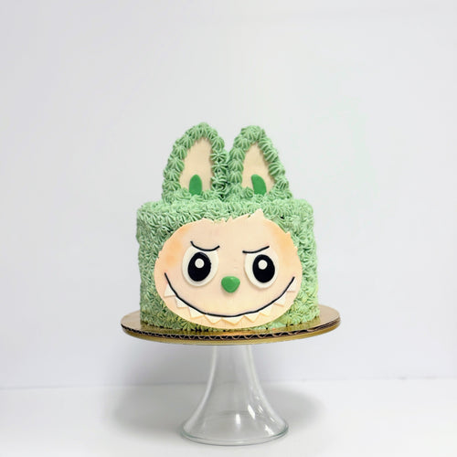 Green cake with a face design on a white background