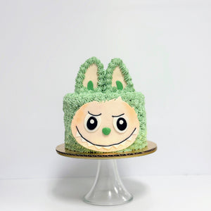 Green cake with a face design on a white background