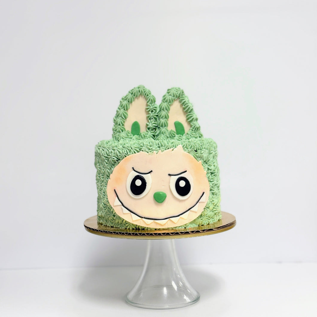 Green cake with a face design on a white background